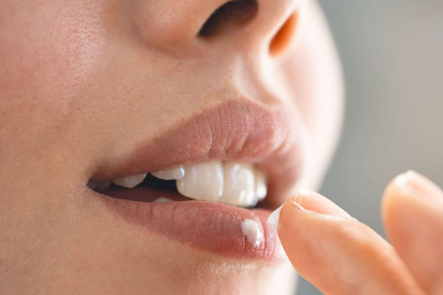 Frau trägt weiße Paste auf Lippen auf