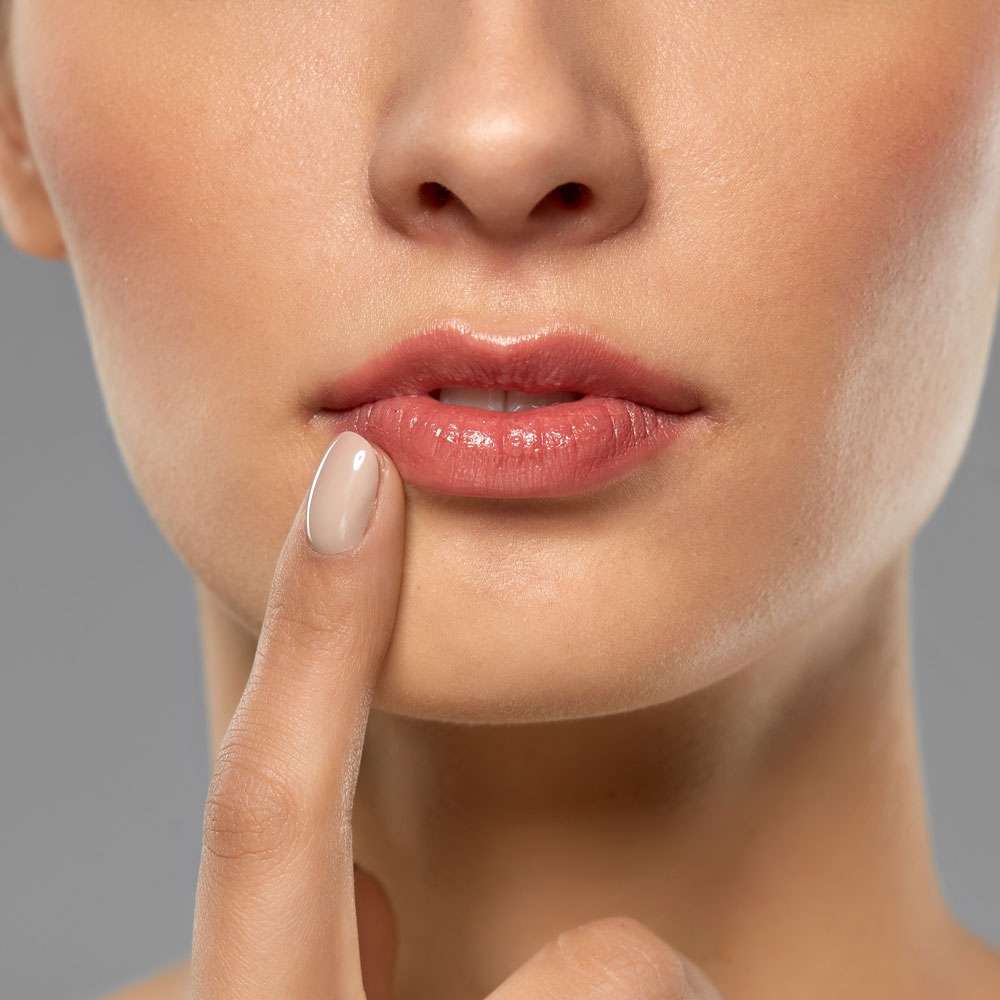 Frau berührt ihre Lippe