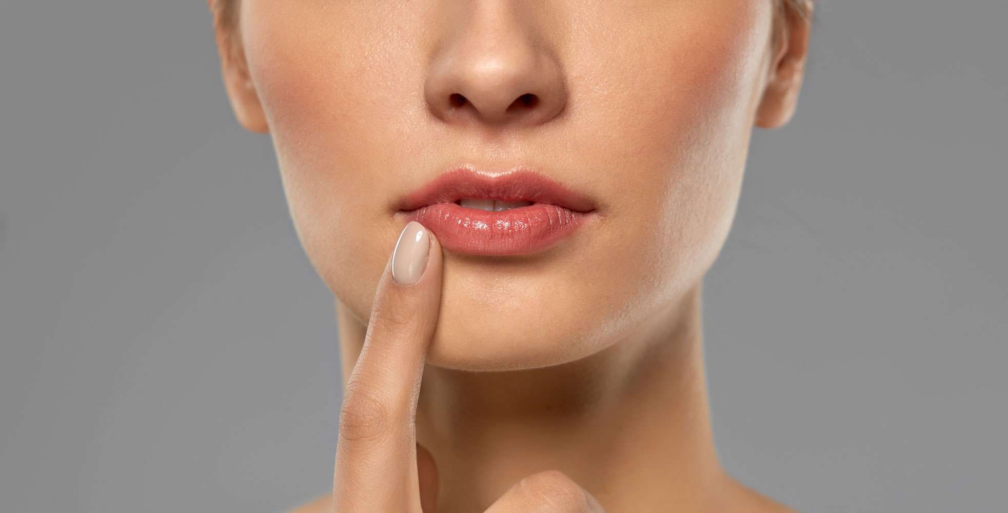 Frau berührt ihre Lippe